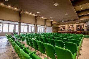 Interno dell'auditorium Ricci. Sala con sedie verdi.