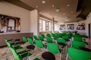 Interno auditorium Pacinotti. Sala grande con sedie verdi.